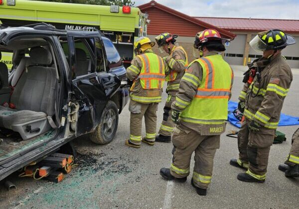 Firefighters inspecting the damaged vehicle at a training.